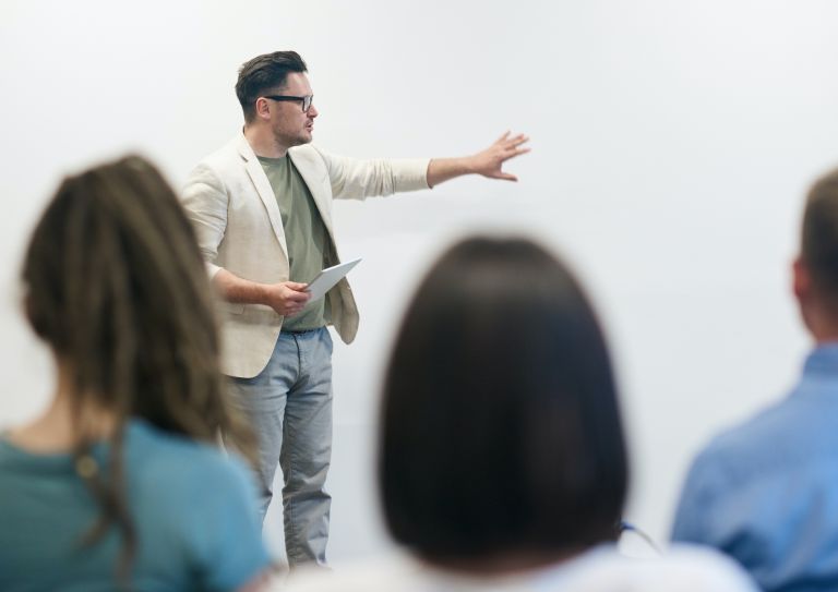 man leading meeting in front of coworkers