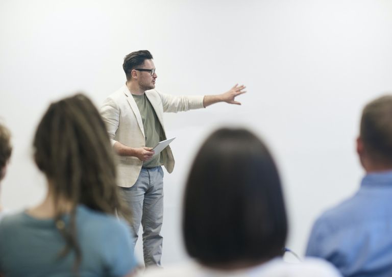 man leading meeting in front of coworkers