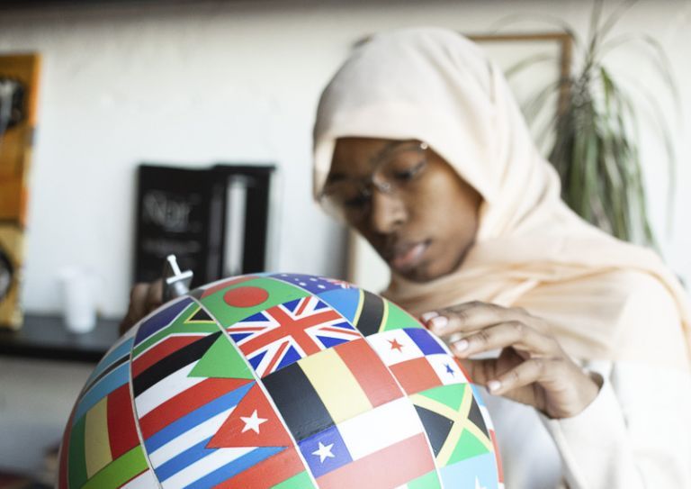 woman holding globe with flags