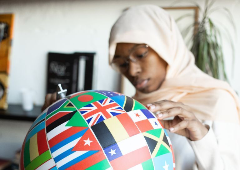 woman holding globe with flags