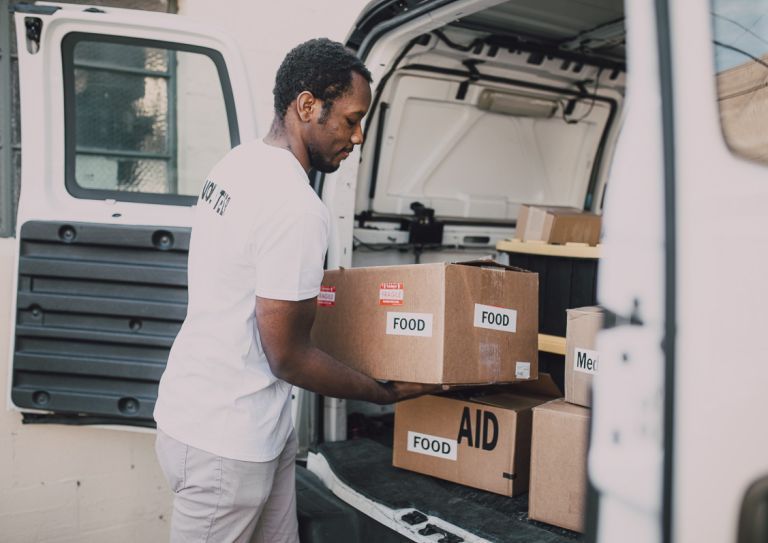 man loading food donations into vehicle