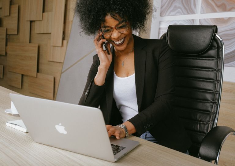 woman using laptop and cell phone
