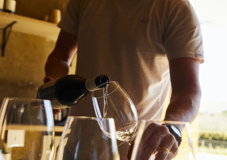 man pouring wine in glass