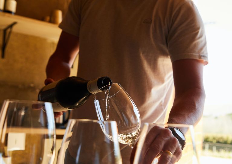 man pouring wine in glass