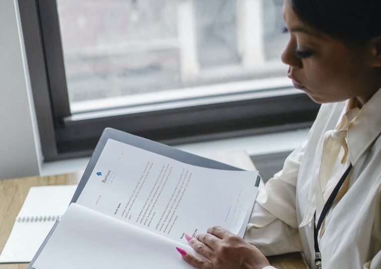 Woman looking at paperwork at desk
