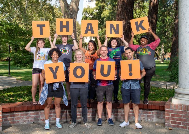 students holding thank you signs