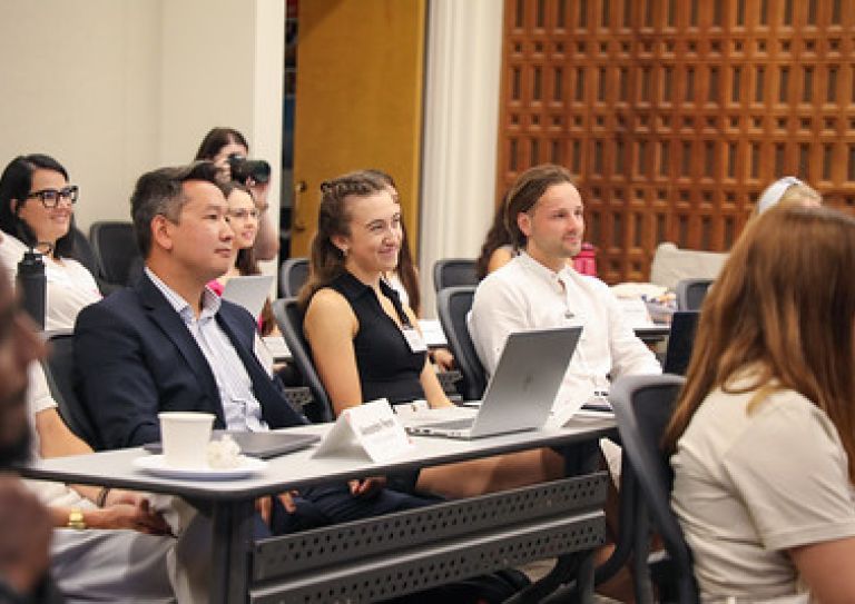 students in a classroom, listening to a presentation