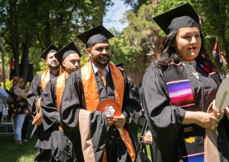 students at a commencement ceremony wearing commencement regalia