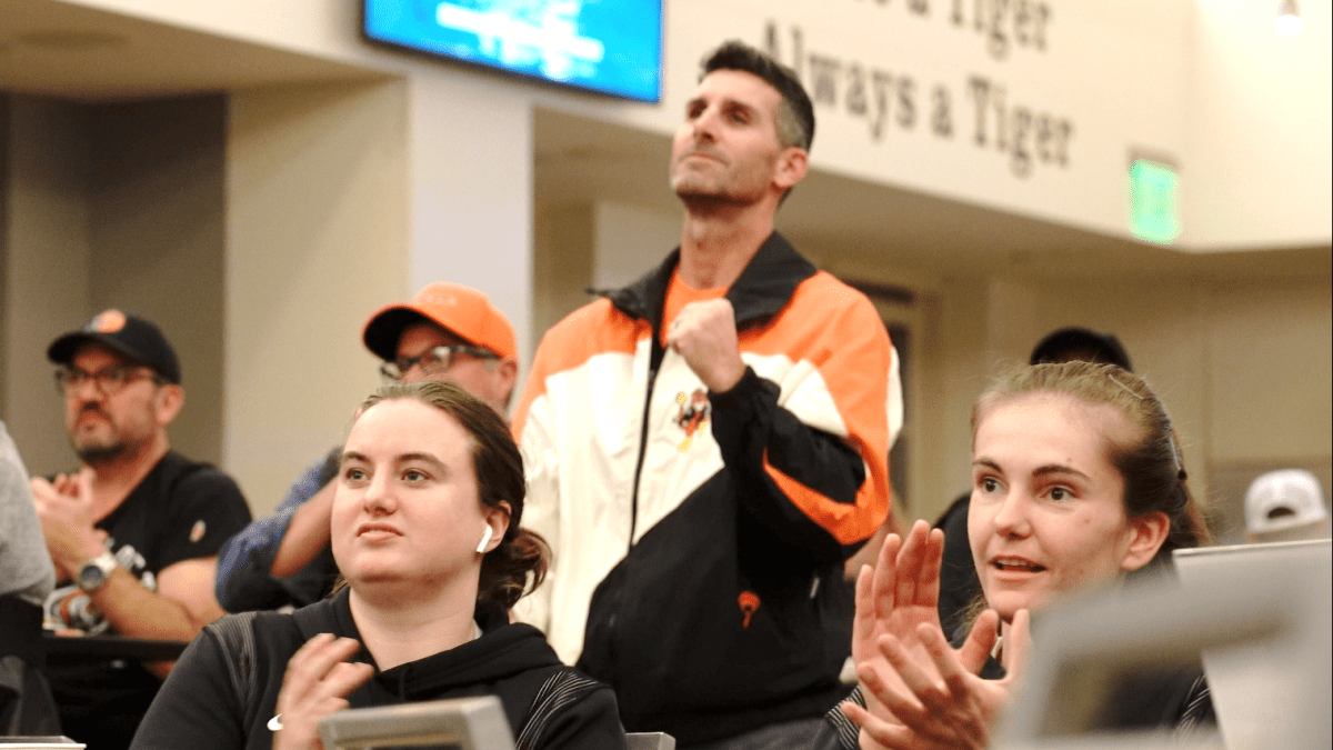fans watch an athletic event broadcast in The Lair