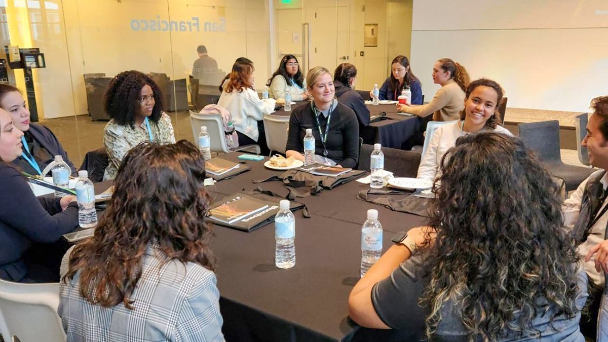 students sit at a table inside Bloomberg offices