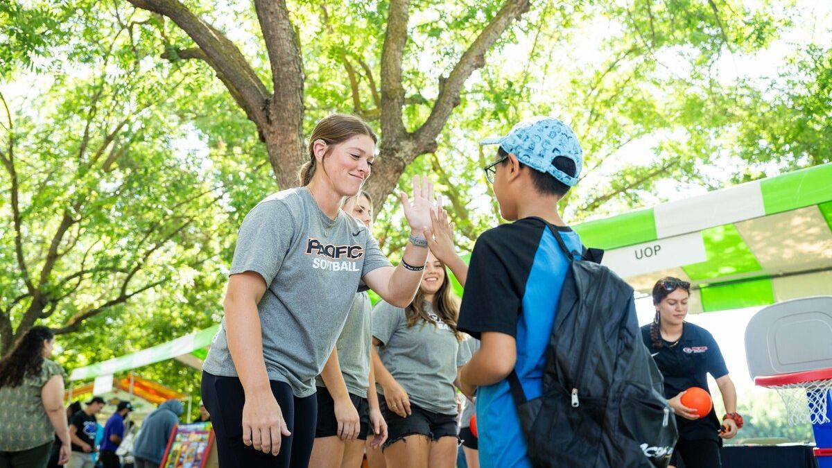 softball player high fives child