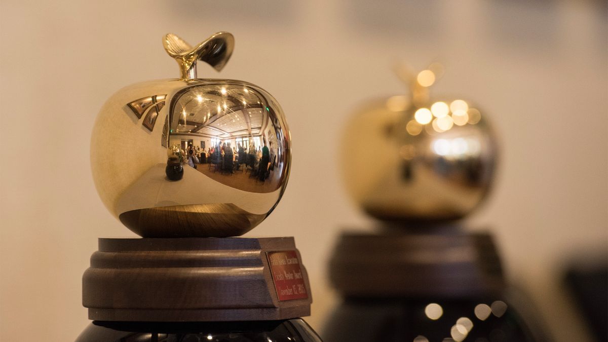 two awards in the shape of golden apples