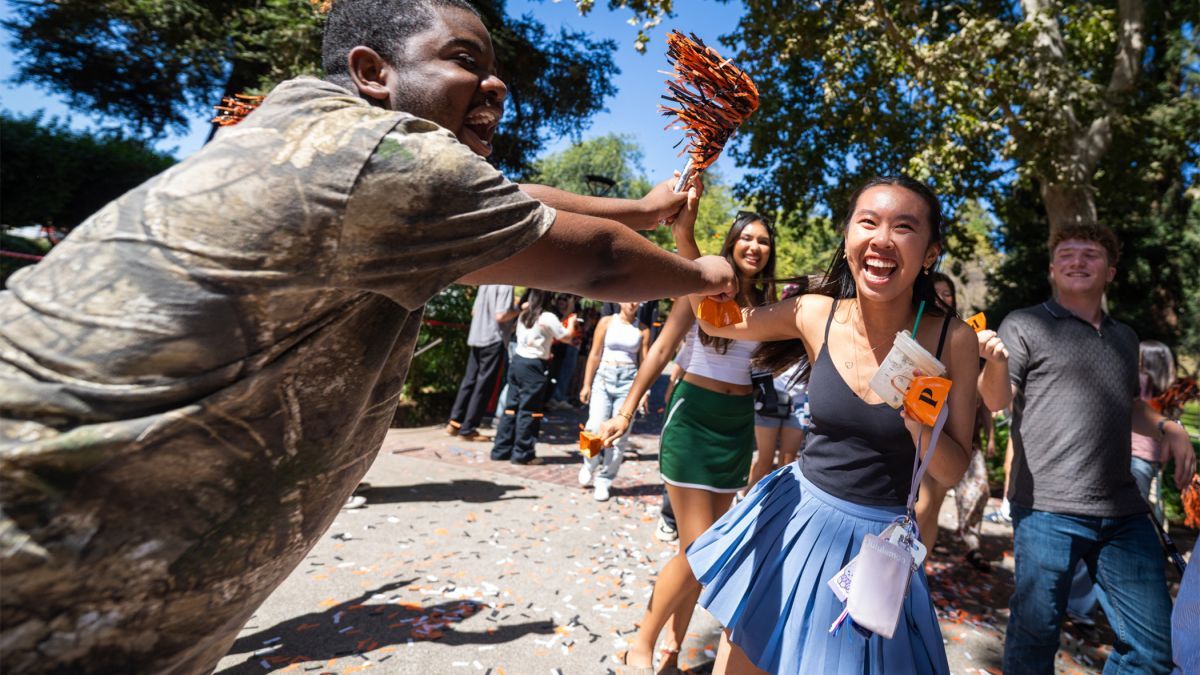 students cheer while walking through campus