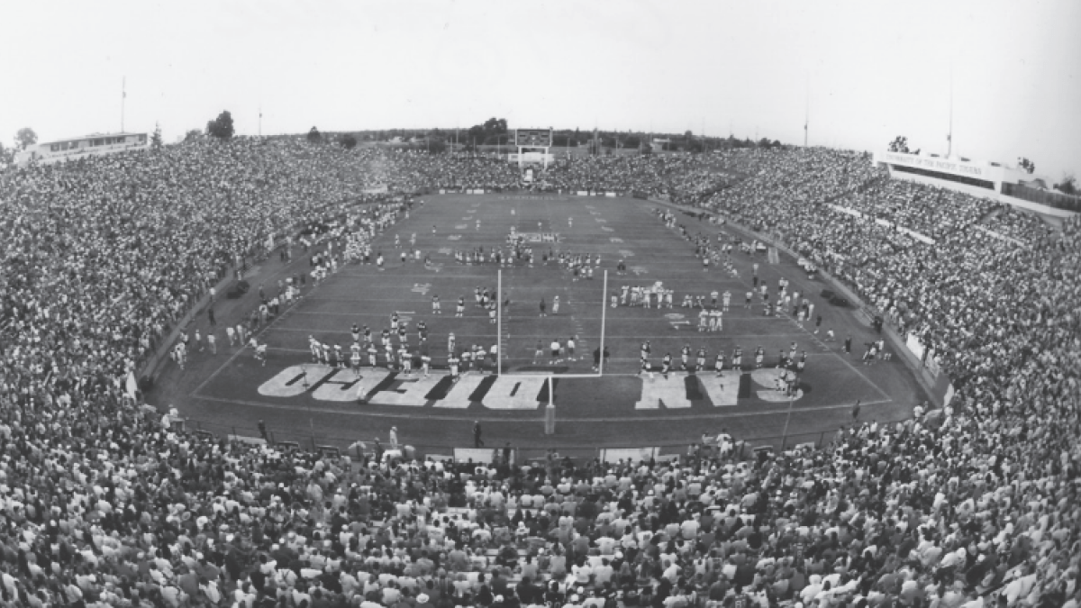 a black and white photo shows a soldout crowd watches a scrimmage at Stagg Memorial Stadium