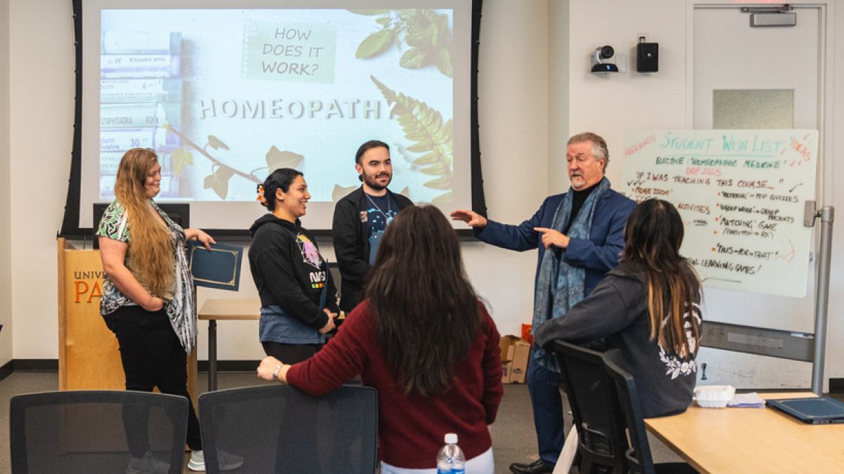 A group of students stands in front of a projection screen