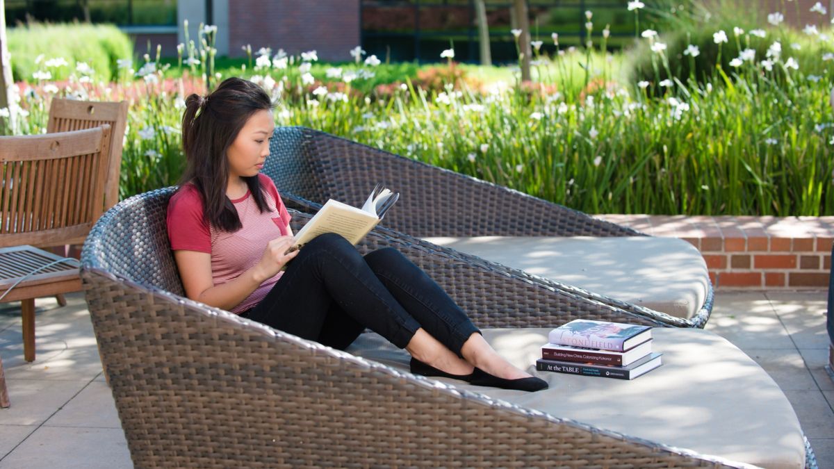 Student reading on the patio