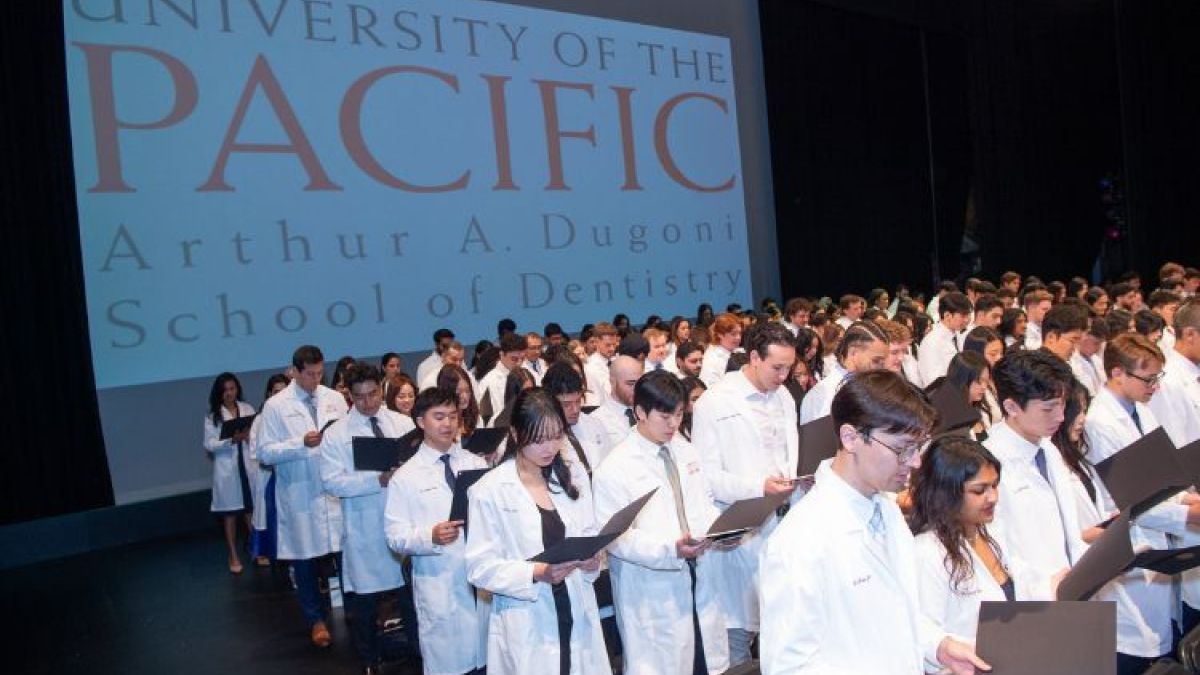 Students stand at their white coat ceremony