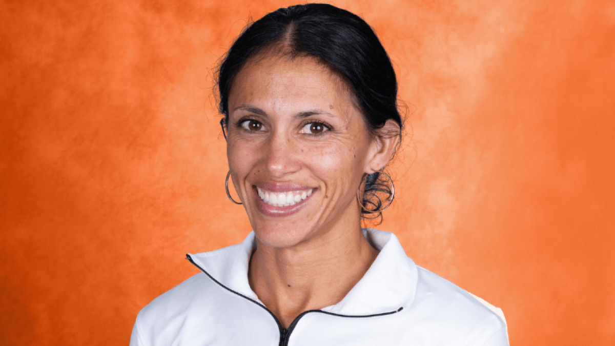 Cherise Roberts smiling with an orange backdrop