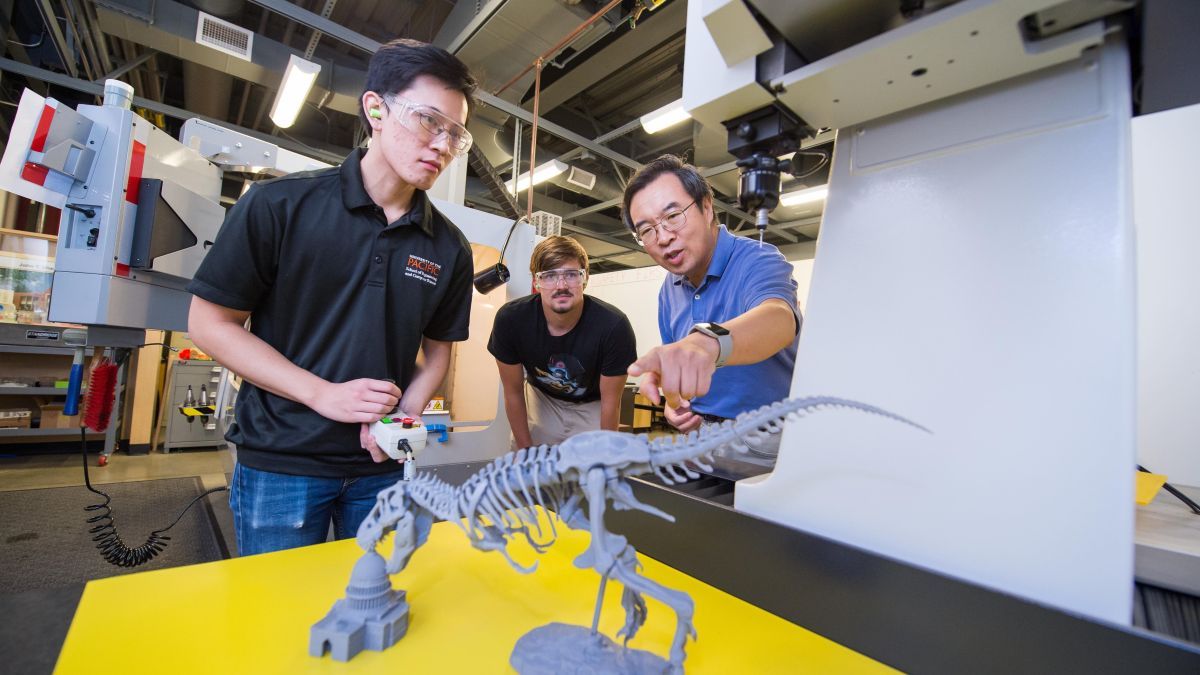 Students building dinosaur