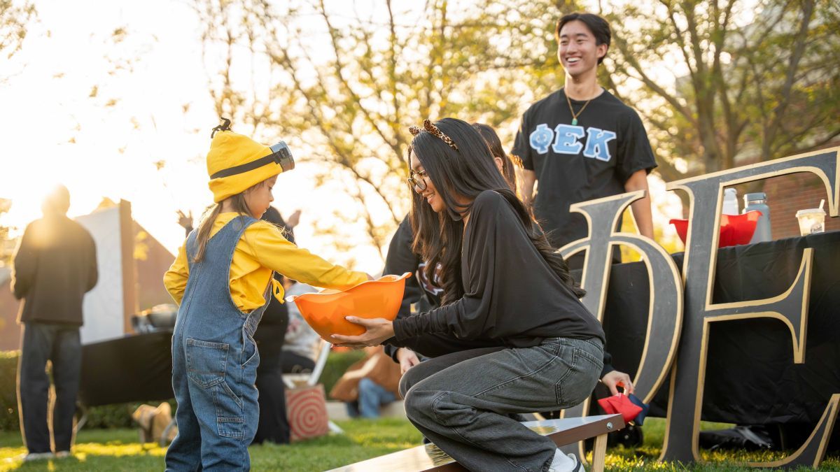Student interacting with a child during Pacific Trick or Treat 