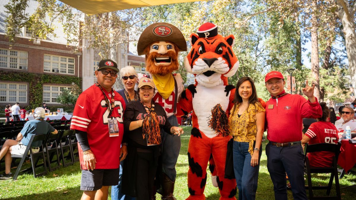 Alumni smile with Power Cat and Sourdough Sam