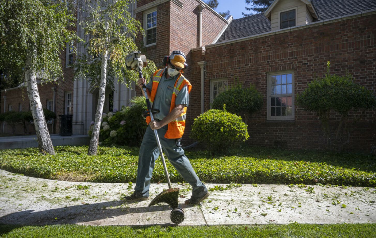 University of the Pacific employee Dillon Krieger uses an edger to trim the lawn on the Stockton Campus on Tuesday, July 14, 2020.