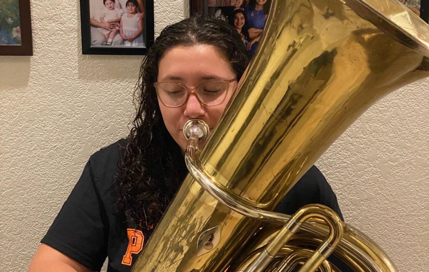 Jolene Villavicencio at home with the tuba the Conservatory of Music loaned her.
