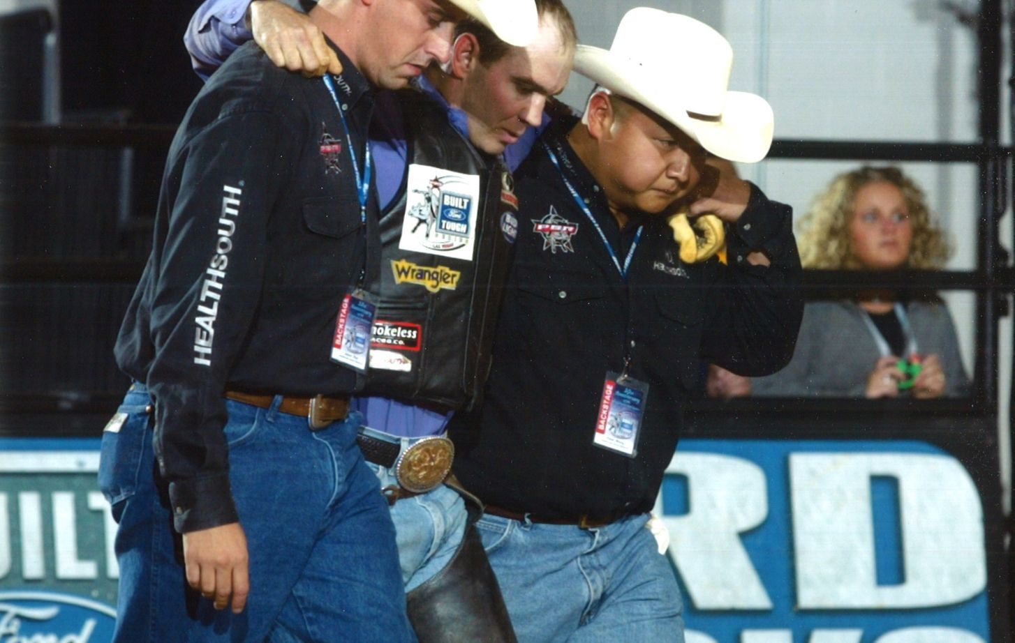 Peter Wang (far right) helps an athlete at a Professional Bull Riders event.