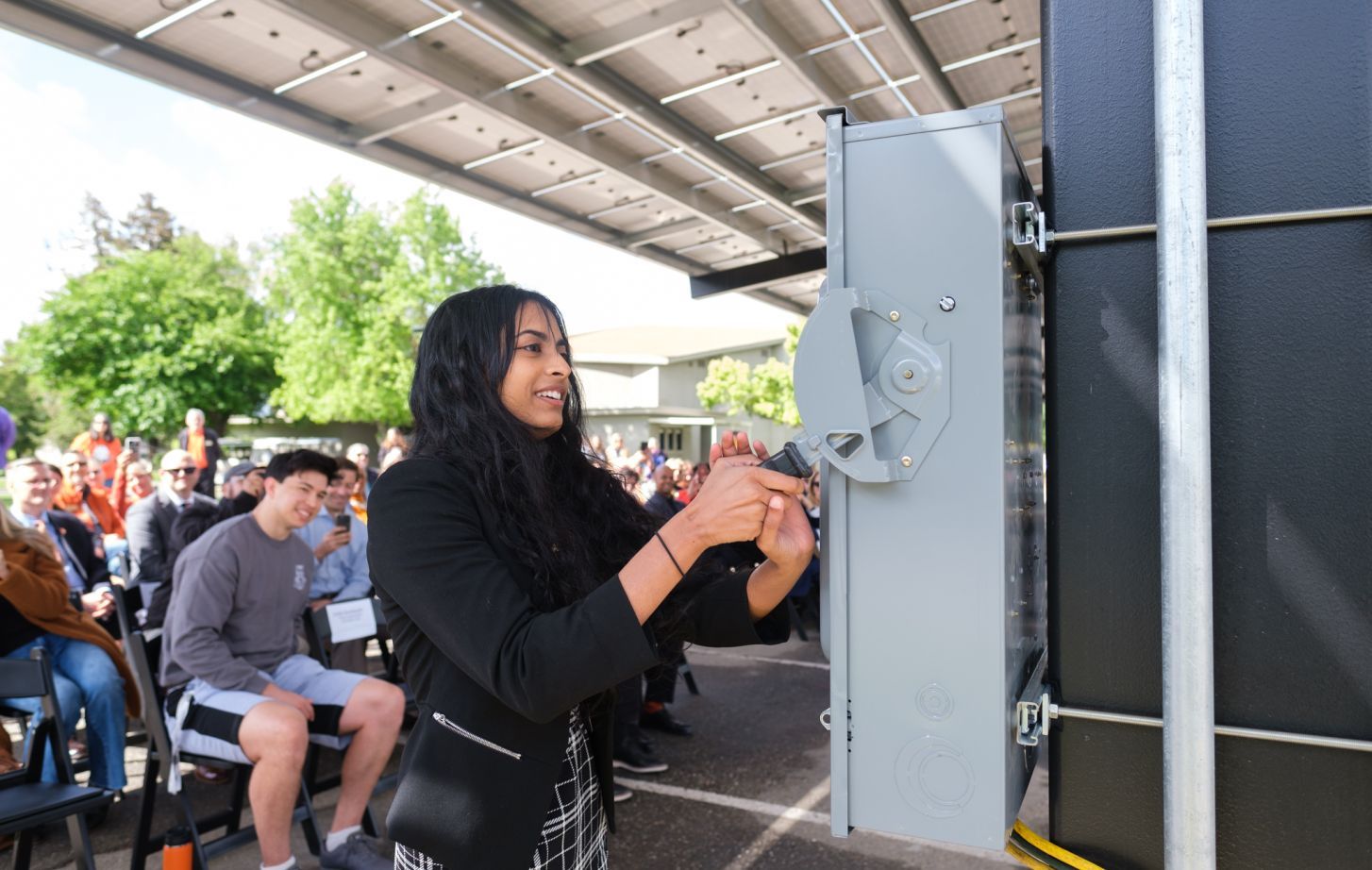 A student "flips the switch" for the solar panels