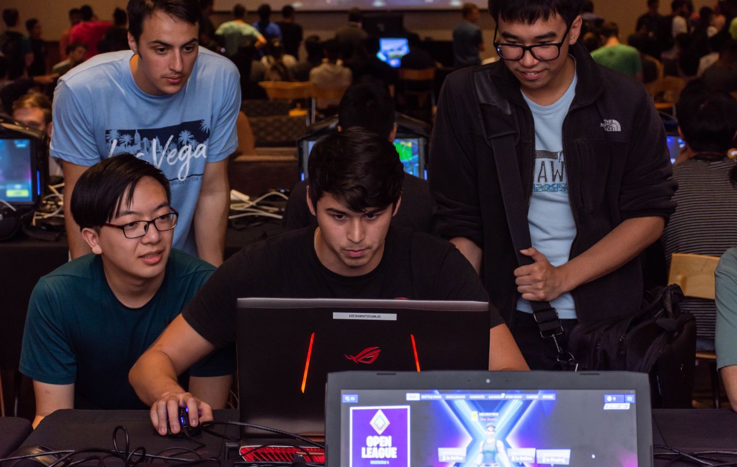 students gather around a computer to play eSports