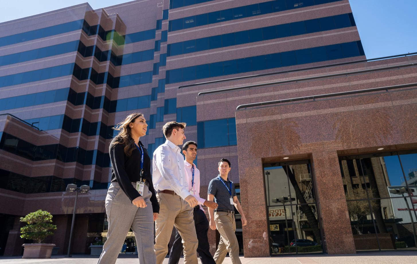 Four students walking in front of Stockton city building