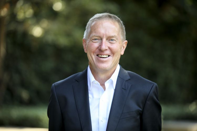 A portrait of Kevin O’Keefe in front of a green background 