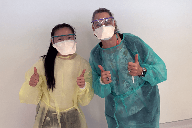 two gowned people giving the thumbs-up signal