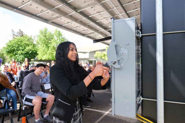 A student "flips the switch" for the solar panels