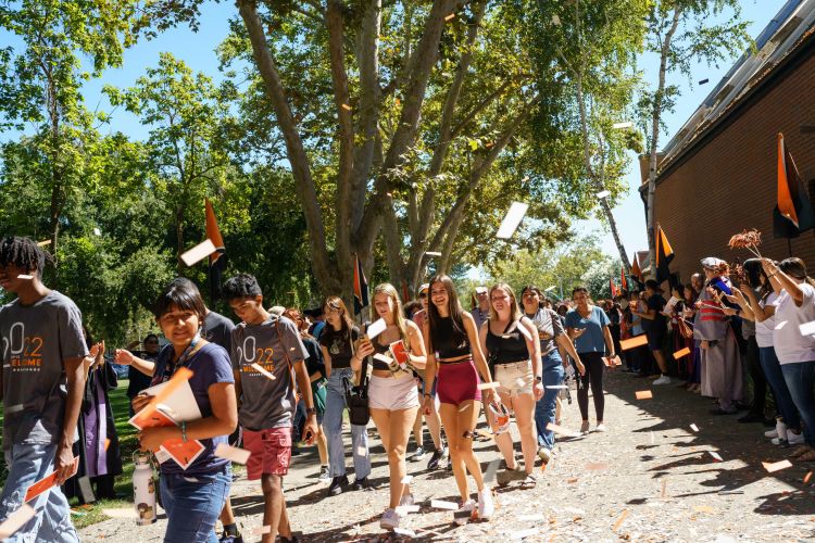 Students walk through a confetti parade.