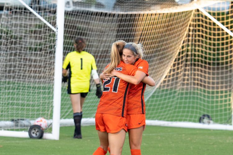 two soccer plays hug on the field