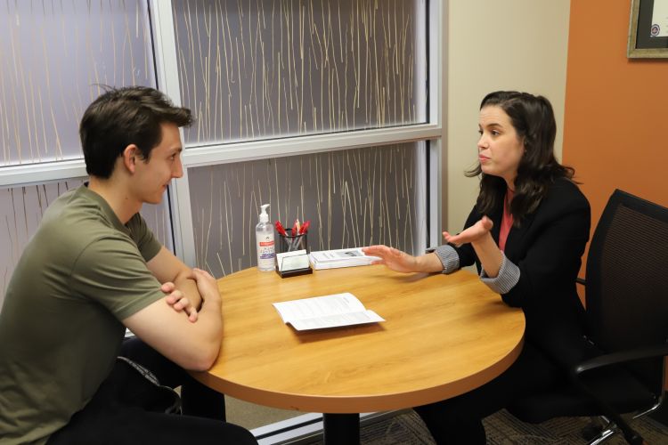 two people talking while sitting at a table