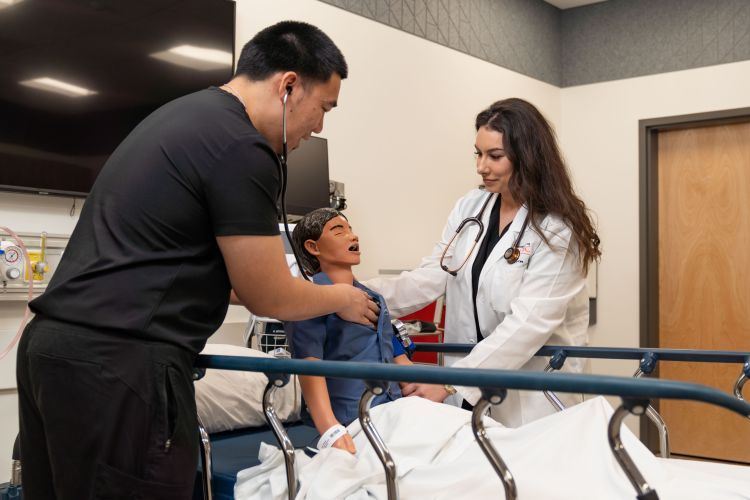 nursing students work with a mannequin in the clinical skills lab