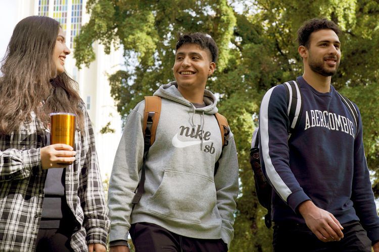 three students walk together on campus