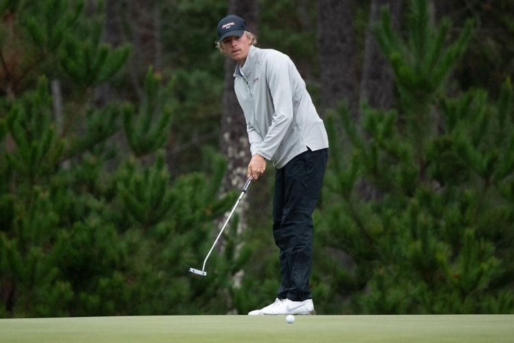 a student stands on a golf course