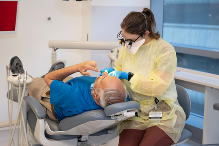 a dental student works on a patient