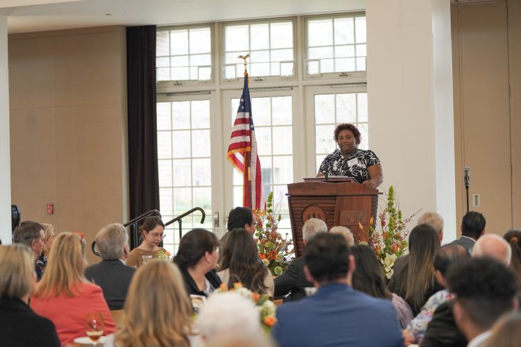 Cynia Manning speaks at a podium during the luncheon.