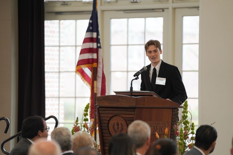 Tristan Allen speaks at a podium during the luncheon