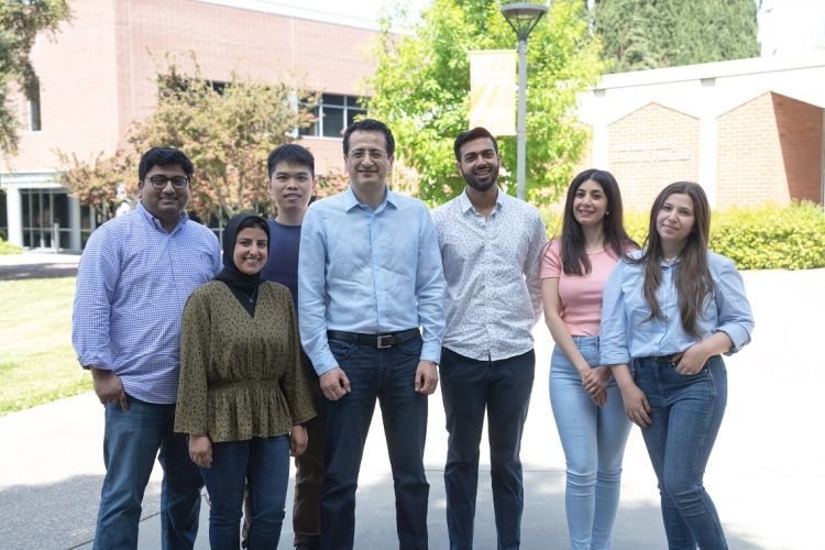 six students and a professor pose for a photo