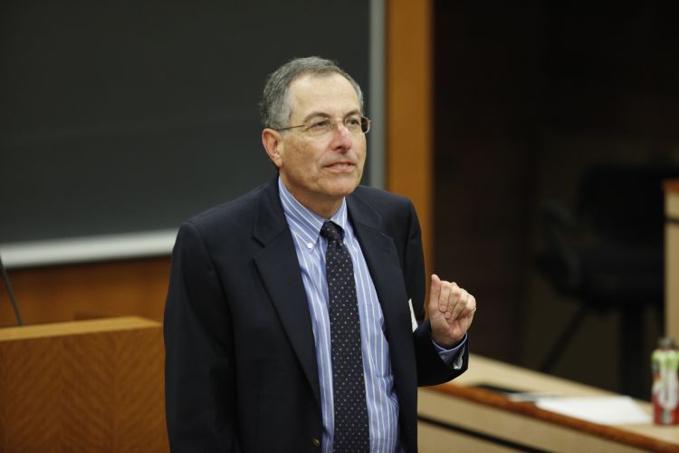 A man in a suit teaches a class