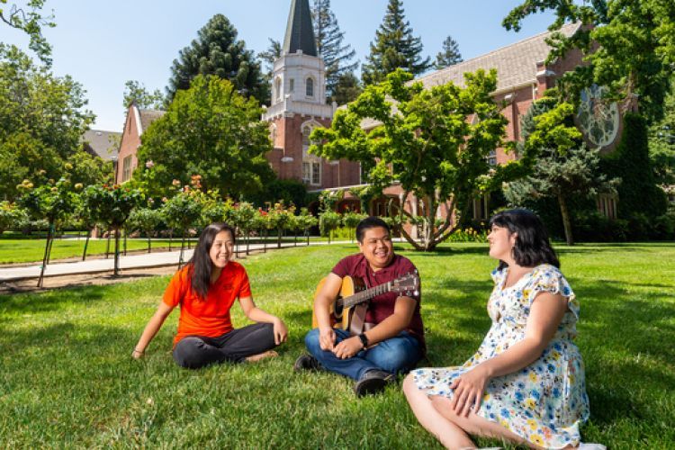 students sit on the lawn in front of the methodist church