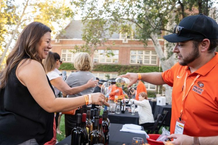a staff member pours wine at the taste of pacific