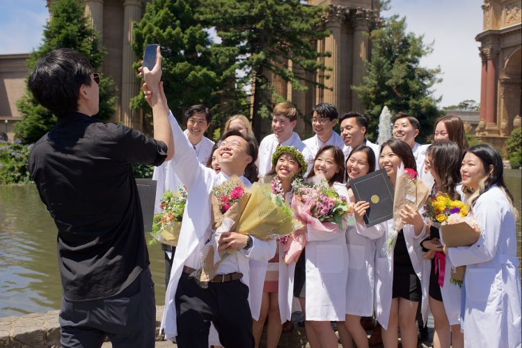 students outside in a group selfie pose at The Palace of Fine Arts