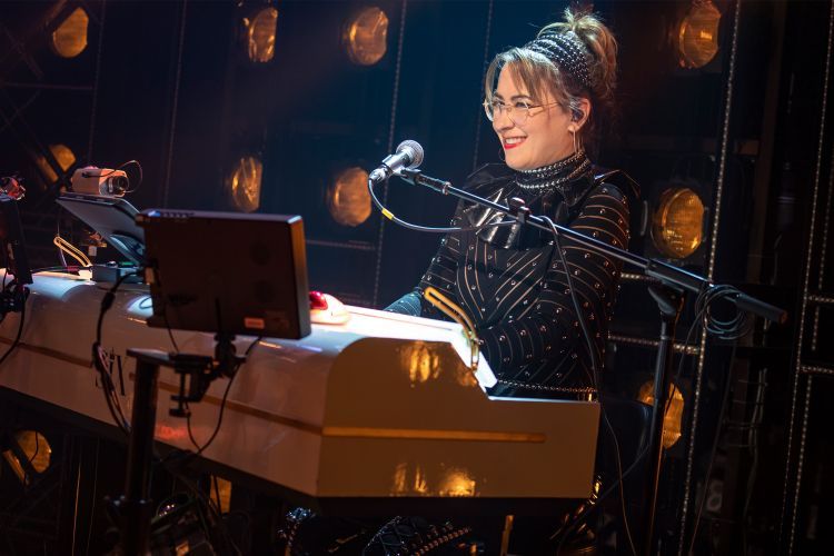 Katie Coleman sits at a keyboard during a musical performance