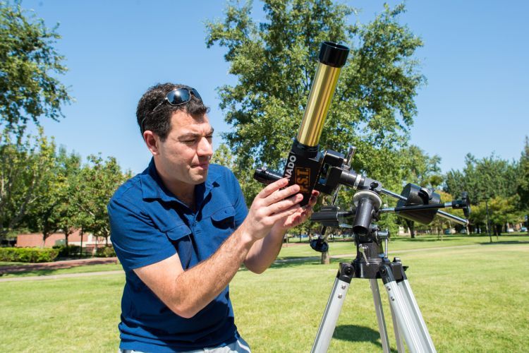 Daniel Jontof-Hutter adjusts a telescope